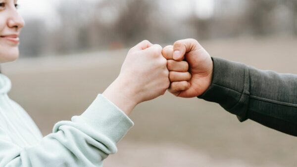 Assertiviteitscoaching op school - Twee handen die elkaar een boks geven