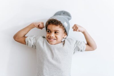 Child with hat poses with his 'muscle' for power kids